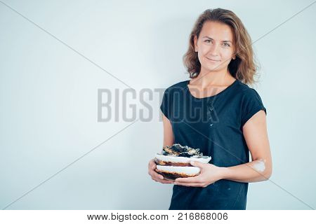 potter, tools, ceramics art concept - handsome young brunette female stand with finished utensils, smiling ceramist at workplace with baked cups and jugs at background