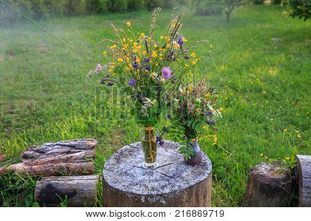 Handmade beautiful bouquet of bright wildflowers on a background of green grass. Latvia, Ligo