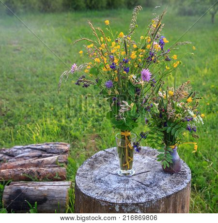 Handmade beautiful bouquet of bright wildflowers on a background of green grass. Latvia, Ligo