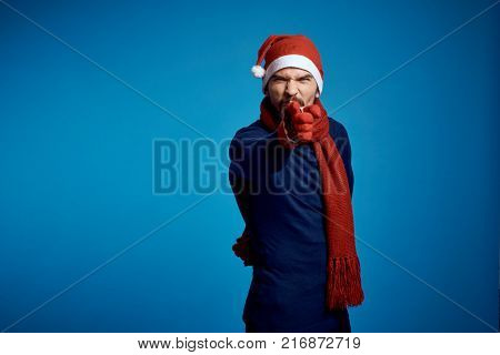 man pointing forward and frowning eyebrows, blue background, free space for copying, new year.