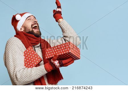 a man holds an open box in his hands, raised his hand up and rejoices, a holiday, a new year, a free space for copying.