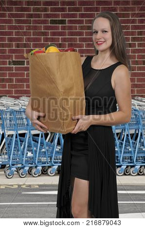 Beautiful woman grocery shopping holding a brown paper bag