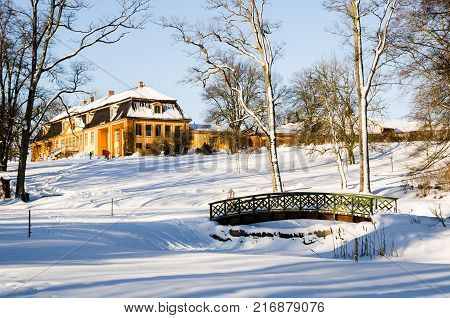 Wooden arch footbridge on a snow covered landscape. Bogstadvannet area in Oslo, Norway. Winterscape