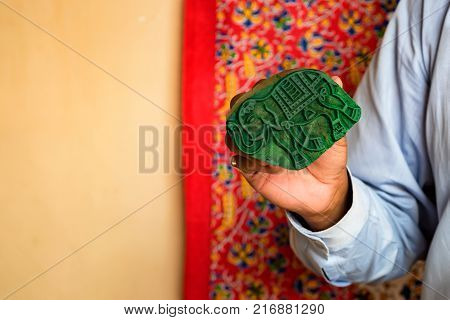 Close up stamp applying dye on cloth