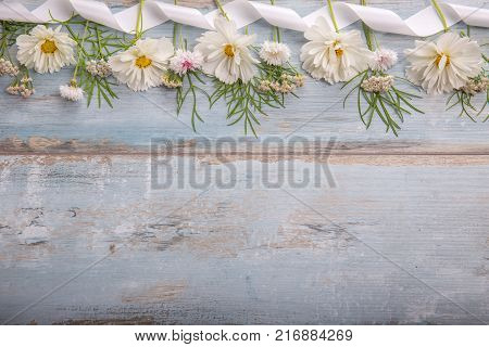 A bouquet of white flowers cosmea on blue rustic boards. Copy space. Mother's, Valentines, Women's, Wedding Day concept.