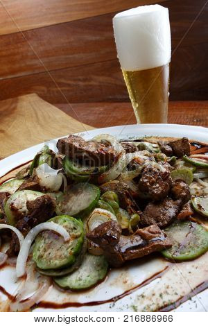 Jilo with meat in sauce and cold beer