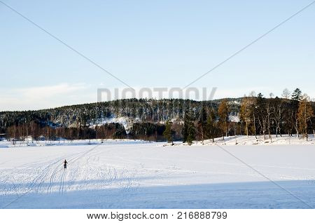 Person practicing ski on frozen lake. Bogstadvannet in Oslo Norway. Alone in nature