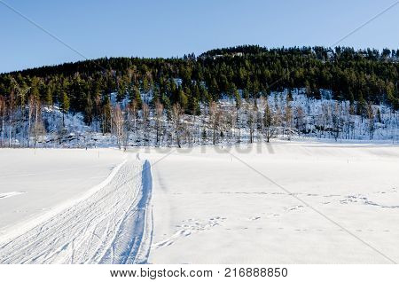 Road path and ski tracks on the frozen lake of Bogstadvannet in Oslo Norway. Inspirational peace