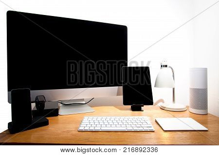 Desk tech. Smart home office desk with connected computer technology gadgets including tablet phone watch smart hub keyboard and hard drive. Modern tech worksation.