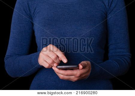 Woman holding and touching screen or display with finger of a mobile phone, cell phone or smartphone. Female businesswoman typing a message or browsing the internet for apps on wireless digital device
