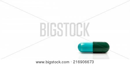 Blue green antibiotics capsule pill isolated on white background with copy space. Drug resistance concept. Antibiotics drug use with reasonable and global healthcare concept.