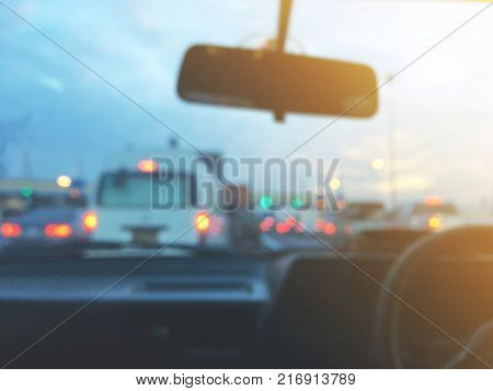 Abstract blurred background of car cockpit at pay toll station on tne traffic jam evening.