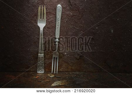 Still life- vintage forks. Rusty metal abstract background