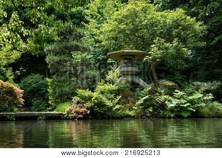 Kanazawa - Japan, June 9, 2017: Historical stone lantern covered with moss in the garden of Oyama ninja Shrine 