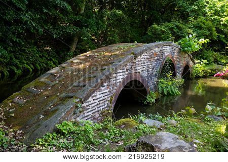 Kanazawa - Japan, June 9, 2017: Historical stone bridge in the garden of the Oyama ninja Shrine in springtime
