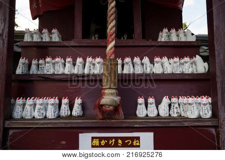 Nagano - Japan,June 3, 2017: Row of small votive Kitsune, fox figurines, animal guardians in front of an Inari Shrine