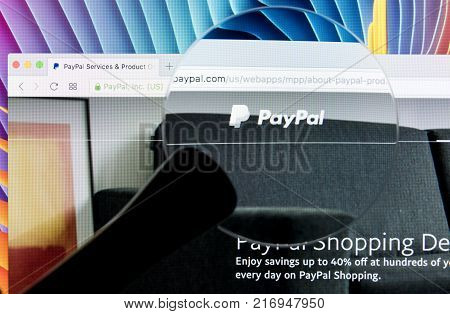 Sankt-Petersburg Russia December 5 2017: Paypal website homepage on a Apple iMac monitor screen under magnifying glass. PayPal is an international e-commerce business allowing payments and money transfers.