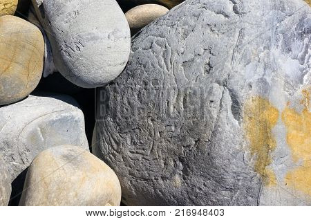 boulders and colorful pebbles on the beach on a warm summer day