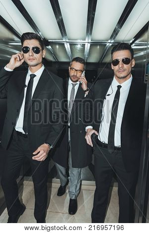 bodyguard obstructing paparazzi when celebrity going into elevator