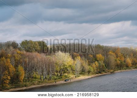 Autumn river Sheksna, view from the bridge gray sky picnic on the beach