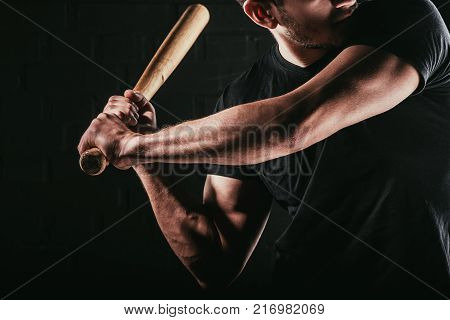 selective focus of man holding baseball balt isolated on black