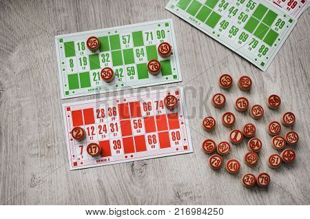 Developing bingo table game old lotto game with wooden elements and cards bingo on a wooden background.