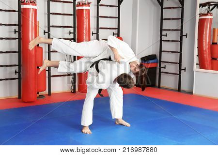 Young man and woman practicing martial arts in dojo