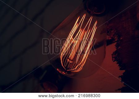 the old warm retro lamp is lit, the light falls on the brick wall