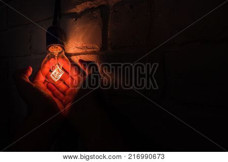 a warm lamp in their hands, light in the palms, a brick wall