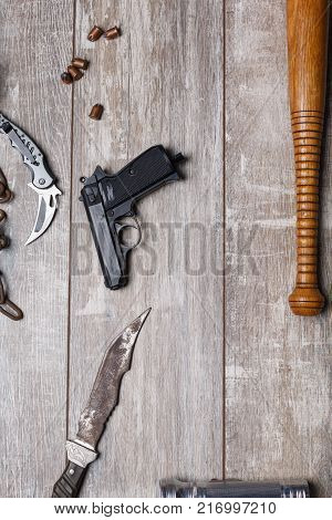 Gun bandits gun, pistol, knife, folding knife and bullets close-up on a wooden floor. View from above