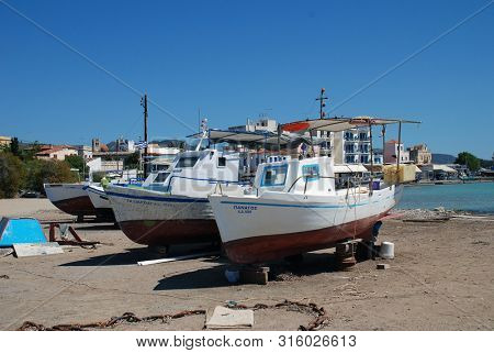 AEGINA, GREECE - APRIL 26, 2017: Boats on the beach at Aegina Town on the Greek island of Aegina. Less than an hour from Piraeus, the island is a popular destination for Athenians. 