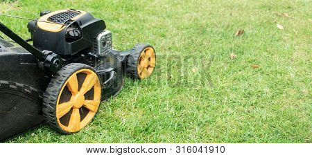 Lawn Mower On Green Grass With Copy Space For Text. Garden Work Concept Background Banner