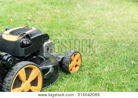 Lawn Mower On Green Grass With Copy Space For Text. Garden Work Concept Background Banner