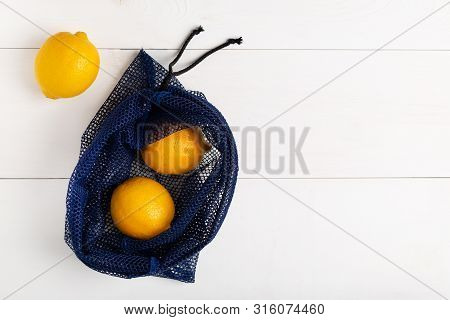 A Reusable Shopping Bag With Lemons On White Background