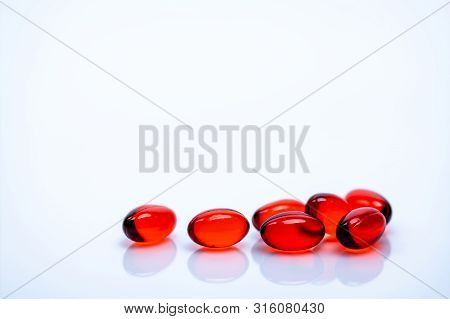 Red Soft Gel Capsule Pills Isolated On White Background. Pile Of Red Soft Gelatin Capsule. Vitamins 