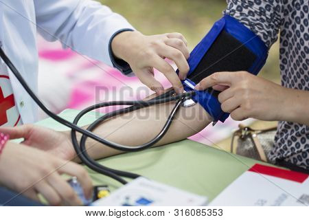 The Doctor Measures The Pressure Of The Patient
