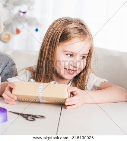Little smiling girl hold present at home