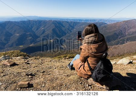 Beautiful Woman Sitting After Hiking And Taking Photo With Phone During Winter Or Autumn In Cataloni