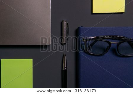 Notebook, Laptop, Glasses And Pen On The Table.