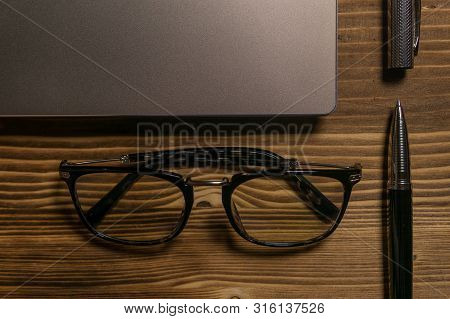 Notebook, Laptop, Glasses And Pen On The Table. Concept Of Business Or Study.