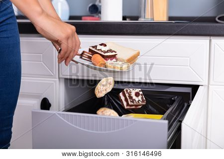 Woman Throwing Food In Trash Bin