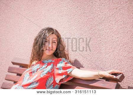 The Pregnant Girl Basks In The Sun. The Concept Of Warm Leisure - A Beautiful Pregnant Girl With Lon