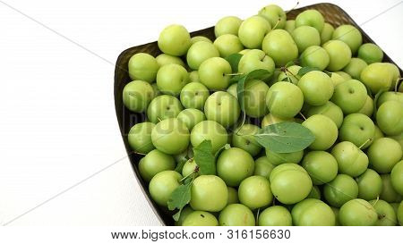 Green Plums On White Ground, Fresh Plums, Sour Plums In A Container, Green And Sour Plums,