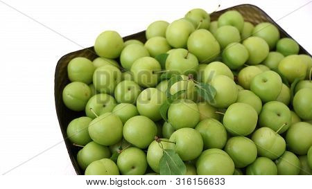 Green Plums On White Ground, Fresh Plums, Sour Plums In A Container, Green And Sour Plums,