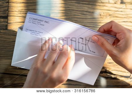 Businessperson Opening Envelope With Paycheck