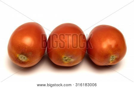 Red Tomatoes Lie In A Row On A White Background