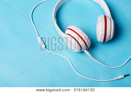White Red Music Headphones On Technology Background Notbook Computer On A Blue Background. Happy Hol
