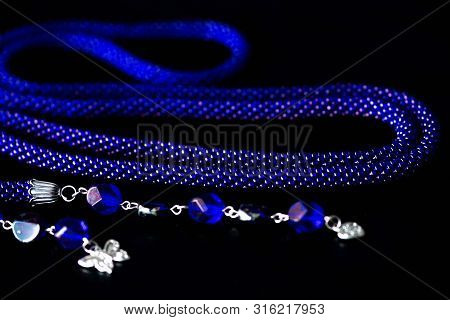 Long Open Necklace (lariat) Blue Color On A Dark Background Close Up
