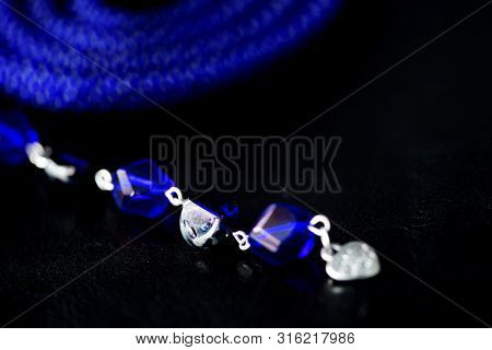 Long Open Necklace (lariat) Blue Color On A Dark Background Close Up