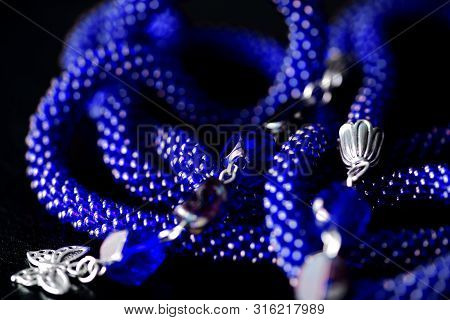 Long Open Necklace (lariat) Blue Color On A Dark Background Close Up